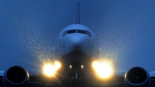 Ein Flugzeug im Landeanflug bei Nacht