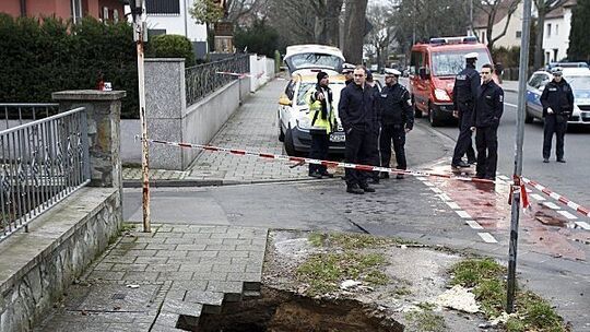 Frau fällt mitten auf dem Gehweg in ein Wasserloch