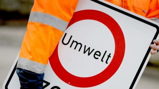 Arbeiter trägt Umweltzonen-Schild