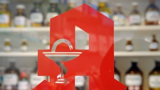 Ein Apothekenlogo an einer Glastür Ein Apothekenlogo an einer Glastür