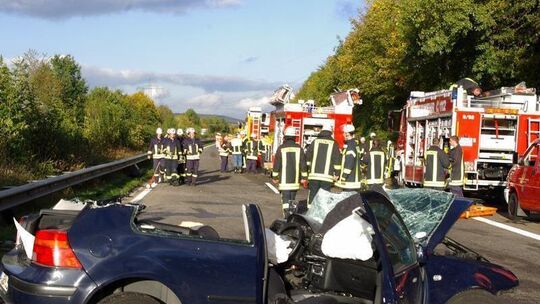 Rettungskräfte vor zertrümmertem Auto