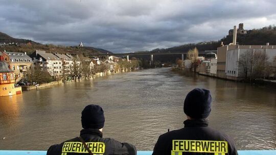 Feuerwehrleute auf einer Brücke über der Lahn