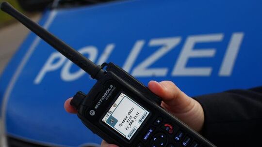Polizeibeamter hält digitales Handsprechfunkgerät