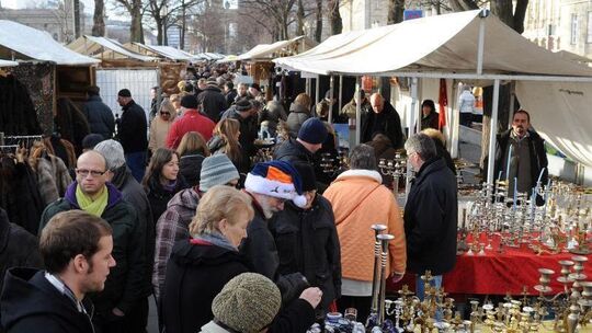 Besucher bummeln über einen Flohmarkt