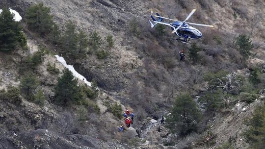 Hubschrauber über Wrackteilen