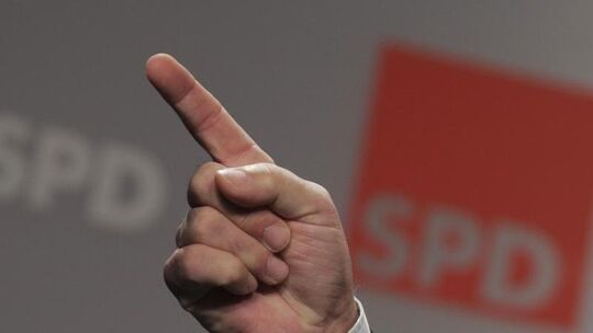 Erhobener Zeigefinger vor SPD-Logo