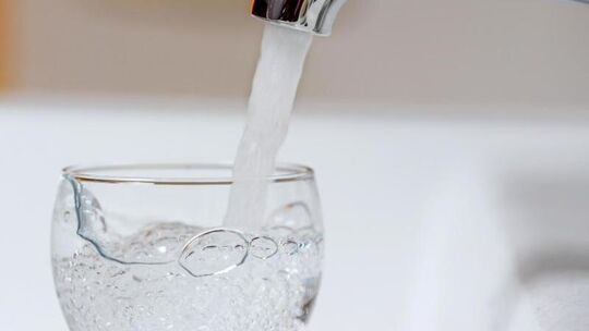 Wasser aus der Leitung fließt in ein Glas