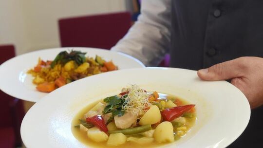 Kellner trägt zwei Teller mit Essen