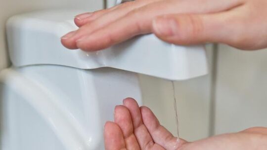 Eine Person desinfiziert sich die Hände