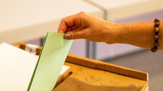 Eine Frau wirft ihren Stimmzettel in die Wahlurne