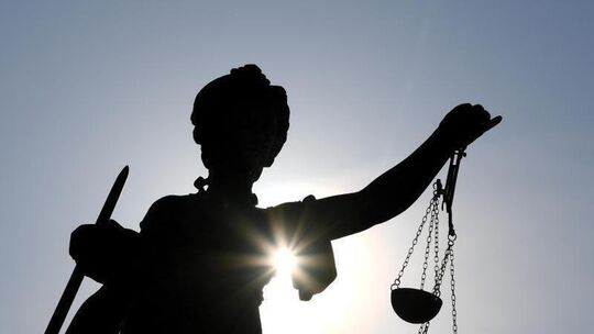 Eine Statue der Justitia steht unter freiem Himmel