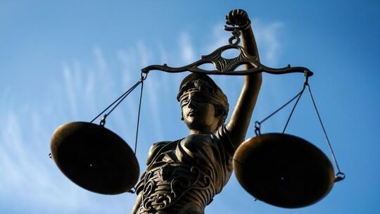 Eine Statue der Justitia hält eine Waage in der Hand