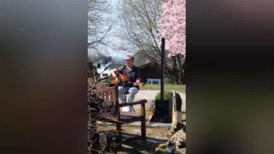 Musiker Peter Kühn spielt auf seiner Gitarre