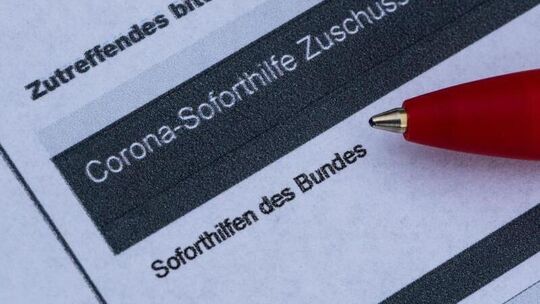 Ein Stift liegt auf einem Antrag für die Corona-Soforthilfe