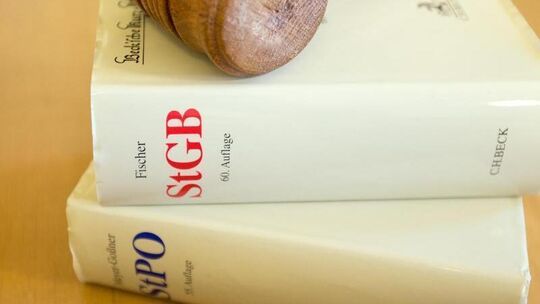 Ein Richterhammer liegt auf einem Strafgesetzbuch