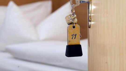 Ein Schlüssel steckt in einer Hotelzimmertür