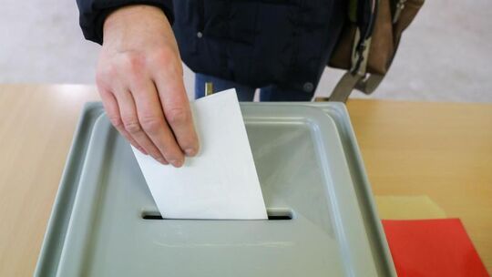 Ein Mann wirft seinen Stimmzettel in die Wahlurne