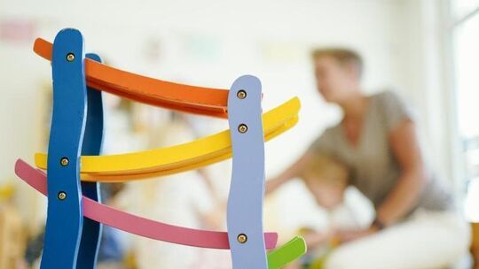 Eine Erzieherin spielt in einer Kita mit Kindern