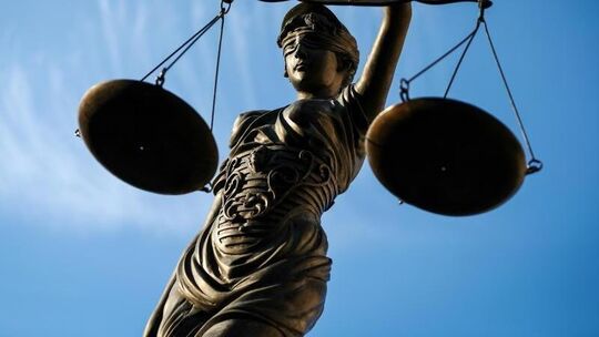 Eine Statue der Justitia steht unter freiem Himmel