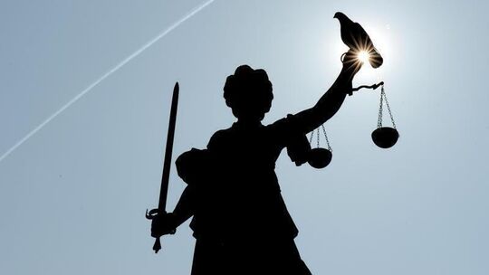 Eine Justitia-Figur steht unter freiem Himmel
