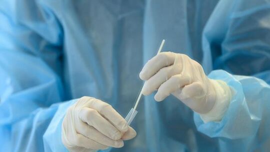 Eine Mitarbeiterin mit einen Antigen-Schnelltest