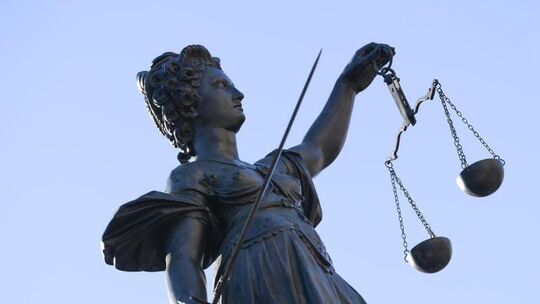 Eine Statue der Justitia steht unter freiem Himmel