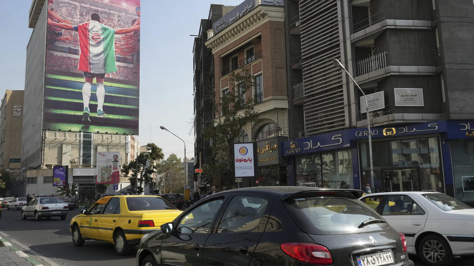 Das staatlich gesponsorte Plakat in den Straßen Teherans passt gut zur derzeitigen Stimmung im Iran bezüglich der Fußball-Weltmeisterschaft: So wenig Begeisterung für ein internationales Turnier gab es noch nie, die landesweiten Proteste überschatten auch den Sport. Foto: Vahid Salemi/dpa