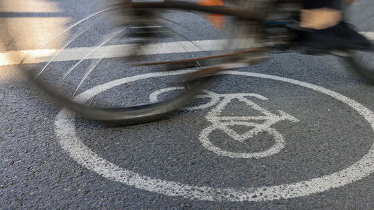Eine Radfahrerin fährt auf einem Radweg. Radfahrerinnen und Radfahrer müssen grundsätzlich am rechten Rand der Fahrbahn fahren. Fahrrad-Mythen zum Weltfahrradtag