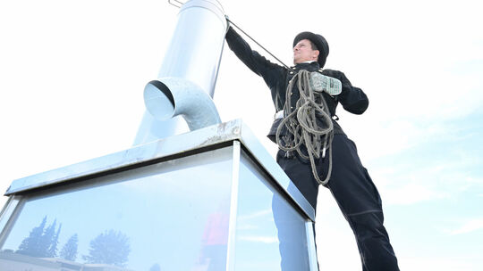 PRODUKTION - 27.09.2023, Baden-Württemberg, Maulbronn: Der Schornsteinfegermeister Markus Banghard steht auf einem Flachdach in Schornsteinfeger Markus Banghard