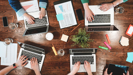 Top view of coworking people sitting together around table. Business meeting of young creative hipsters. Team of analysts make c