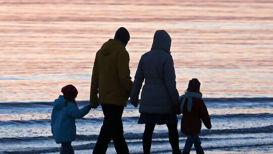 ARCHIV - Eine Familie ist am 16.04.2017 im Licht der untergehenden Sonne an der Ostsee auf der Insel Hiddensee bei Vitte (Meckle Familie