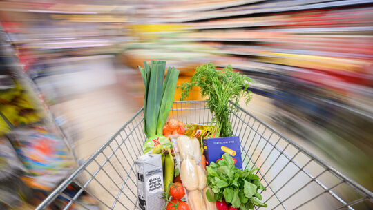 ILLUSTRATION - Ein mit Lebensmittel gefüllter Einkaufswagen wird durch einen Supermarkt geschoben (gestellte Szene, Aufnahme mit Einkauf im Supermarkt