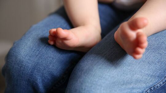 Baby sitzt auf dem Schoß