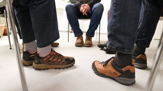 Mitglieder einer Suchtgruppe sitzen im Therapiegespräch