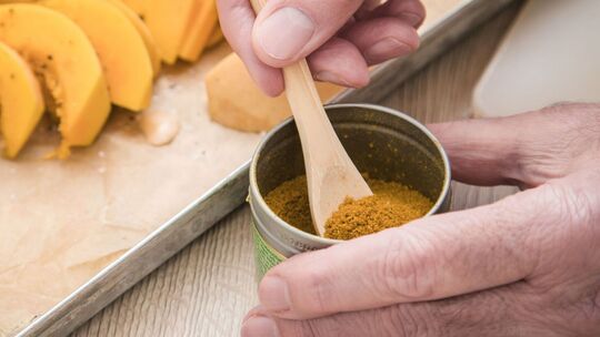 Mann würzt Essen mit einer Gewürzmischung