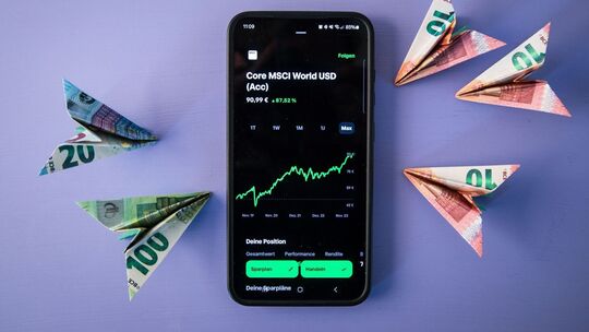 Geldscheinflieger zeigen auf einen ETF Kursverlauf