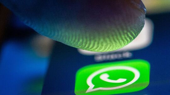 Ein Finger über dem Whatsapp Symbol