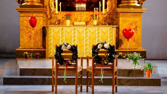 Geschmückte Stühle stehen vor dem Altar einer Kirche