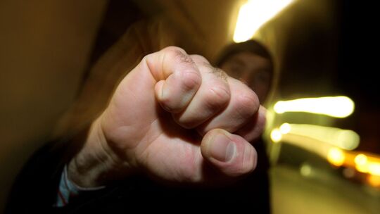 Junger Mann hebt seine geballte Faust