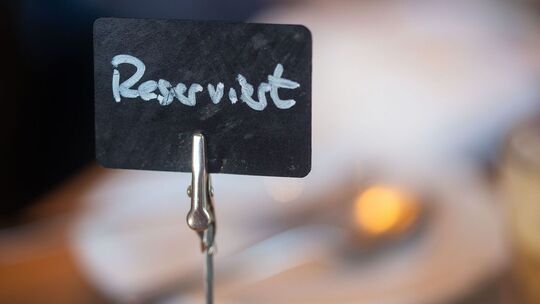 Ein Schild mit der Aufschrift «Reserviert» steht auf einem Tisch