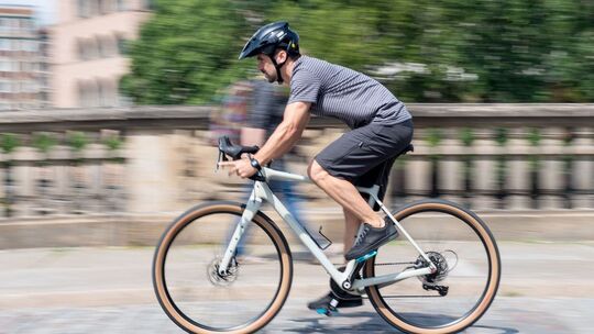 Mann fährt mit einem Gravelbike durch die Stadt