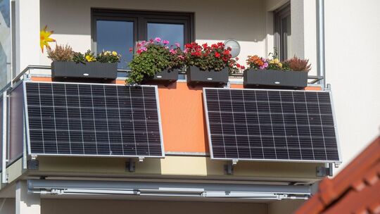 Solarmodule für ein Balkonkraftwerk hängen an einem Balkon