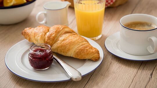 Ein Croissant ist auf einem Frühstückstisch zu sehen