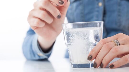 Brausetablette löst sich in einem Glas Wasser auf