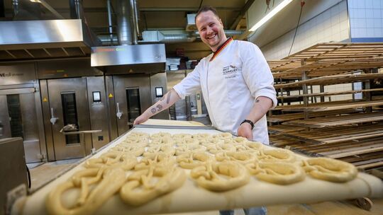 Brot-Sommelier Florian Lutz schiebt ein Blech Brezeln in den Ofen