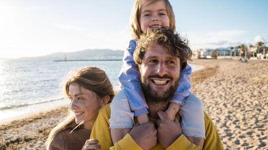 Familie läuft am Strand entlang