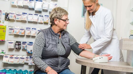 Apothekerin misst den Blutdruck einer Kundin