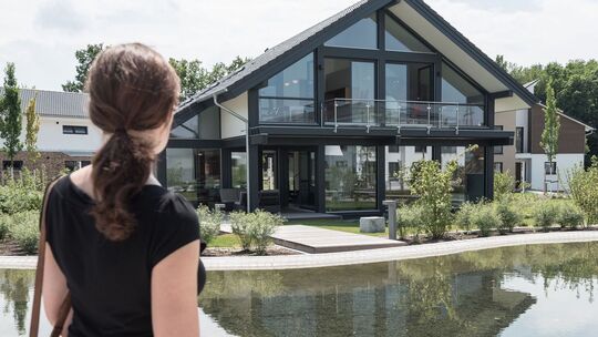Eine Frau schaut auf ein Wohnhaus