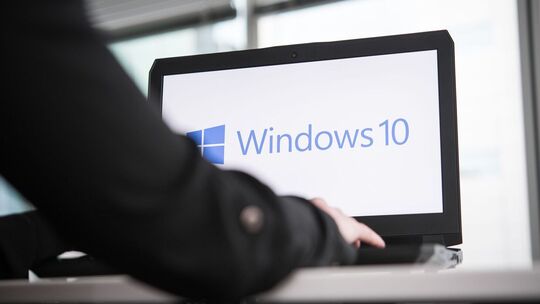 Person an einem Notebook mit Windows 10