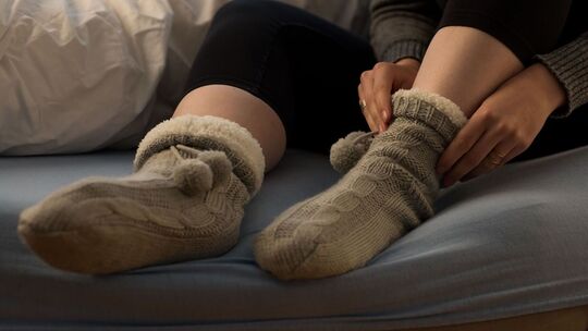 Eine Frau zieht warme Socken an